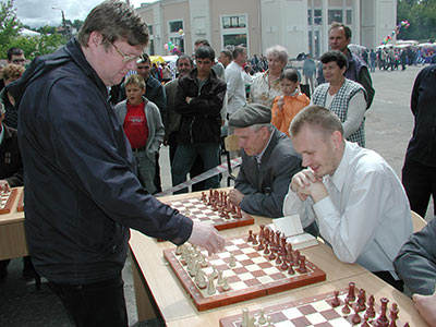 Гроссмейстер дает сеанс одновременной игры на примерно 20 досках